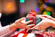 Frauenhände von rechts überreichen Frauenhänden links ein schön verpacktes Geschenk Frauenhände von rechts überreichen Frauenhänden links ein schön verpacktes Geschenk